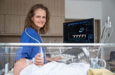 Eine Ärztin macht einen Ultraschall an einem Neugeborenen.