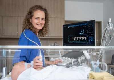Eine Ärztin macht einen Ultraschall an einem Neugeborenen.